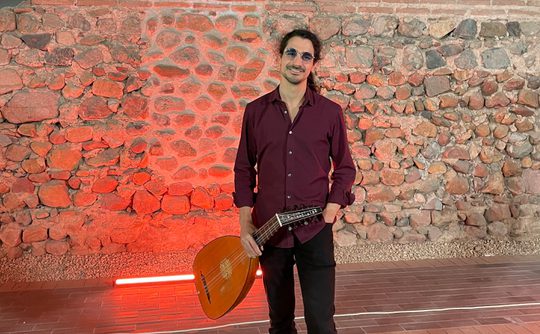 Benslow Music Tutor Sami Brown holding his lute