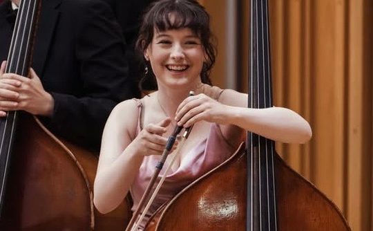 A woman smiling with her double bass