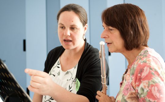 two women - a tutor and student studying music on a stand