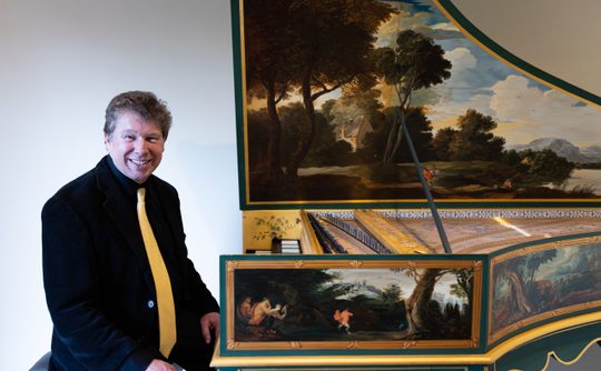 A Benslow Music Tutor sat in front of a harpsichord