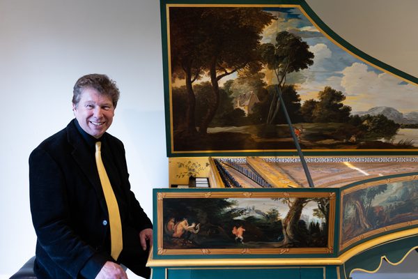 A Benslow Music Tutor sat in front of a harpsichord